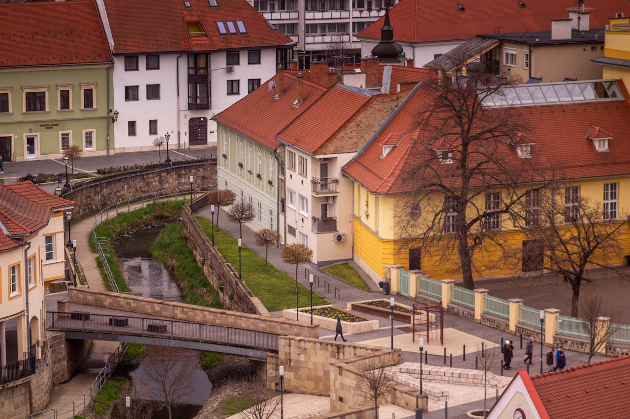 Aerial view of a European town with colorful buildings, a bridge, and a small river.